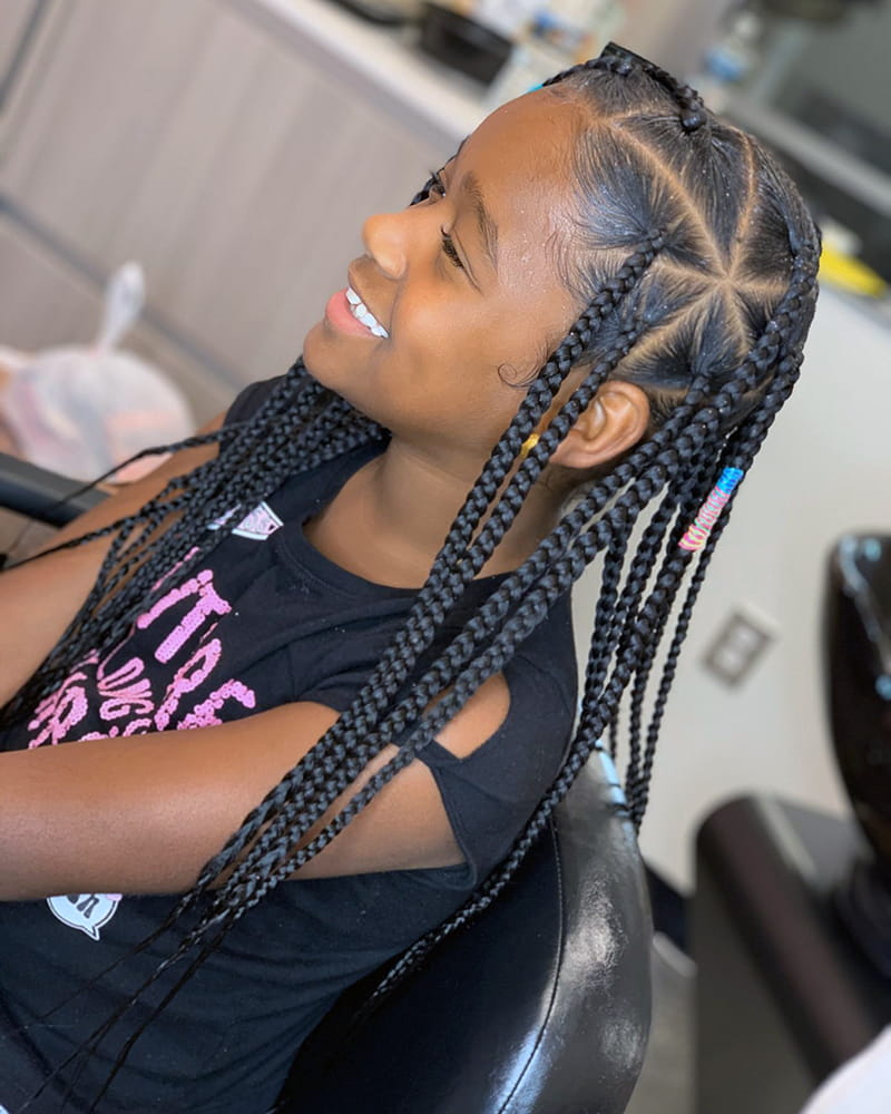 An African American Girl of 12 years is wearing triangle box braids hairstyle.