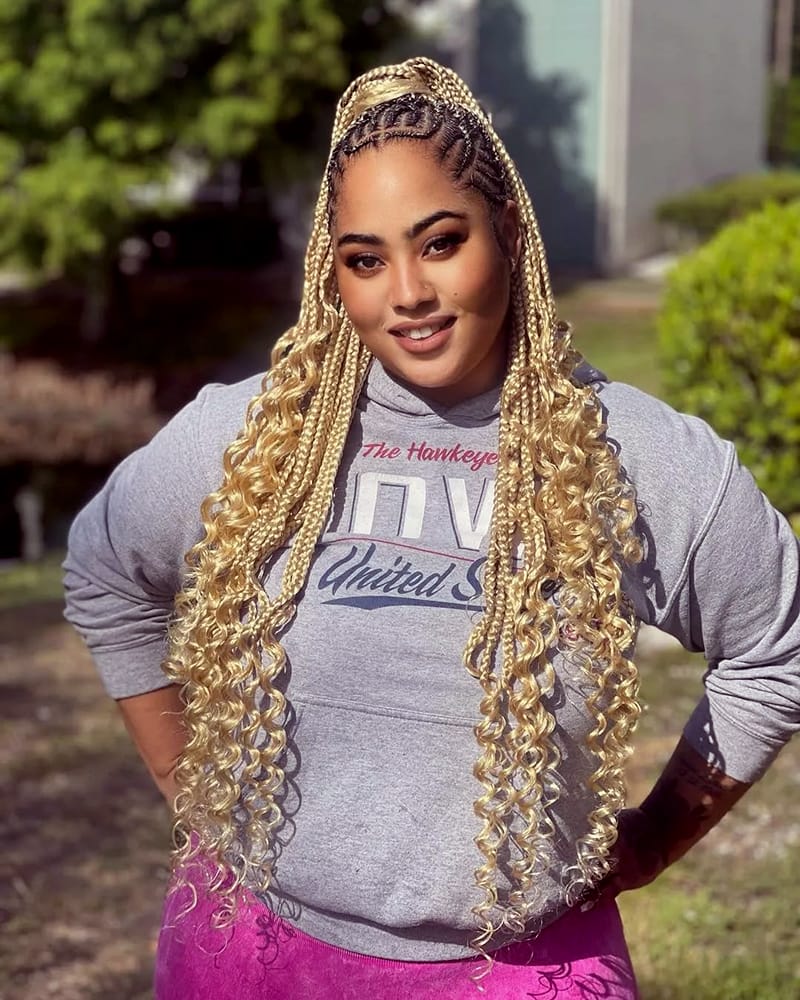 A beautiful woman is wearing a Fulani goddess braids style. She has made a ponytail with the braids.