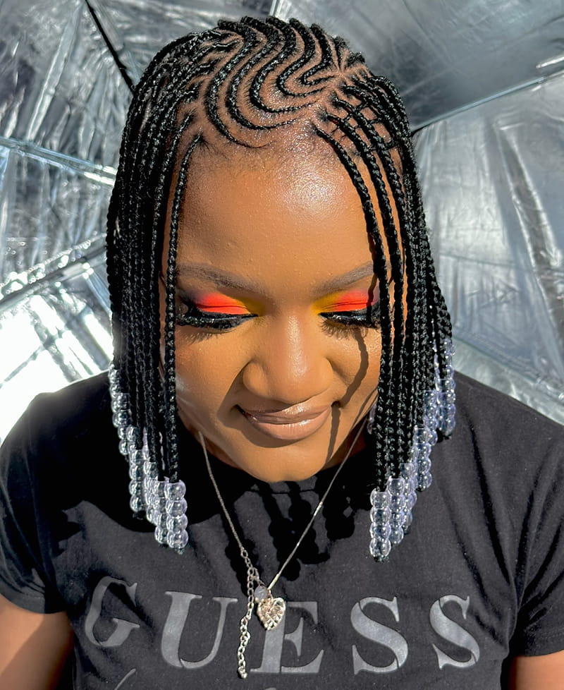 Woman wearing a zigzag cornrow braids with lovely transparent white beads. This a braid style that is usually worn by the Fulani people.