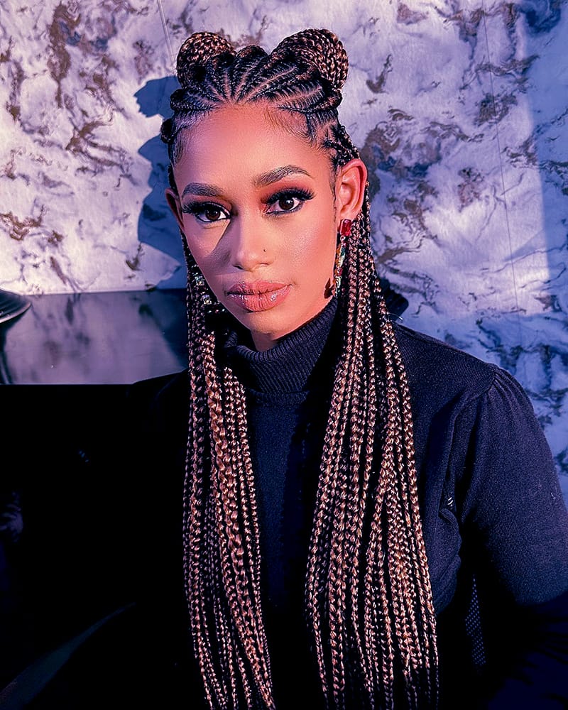 Woman wearing a Fulani Cornrow Hairstyle with two lovely braided knots.